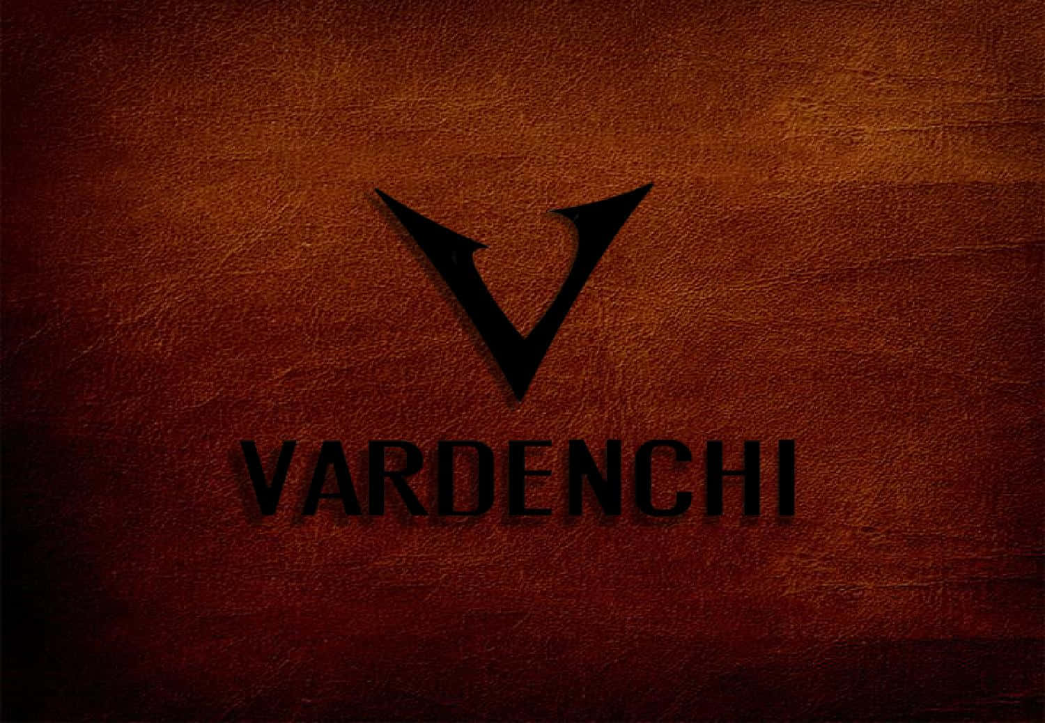 Vardenchi 桌布 壁紙 — 一個大膽的黑色「V」標誌和單詞 VARDENCHI 居中放置在豐富紋理的棕色皮革背景上。
