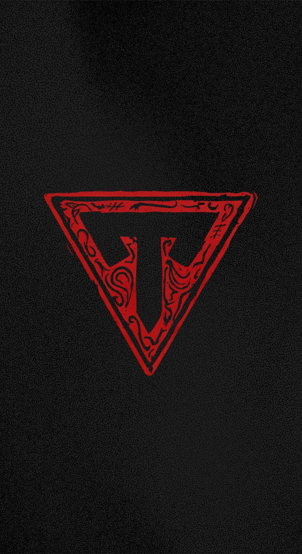  壁紙 — 一個大膽的紅色三角形徽章，帶有複雜的漩渦和中央的「T」，在帶有紋理的黑色背景上脫穎而出。