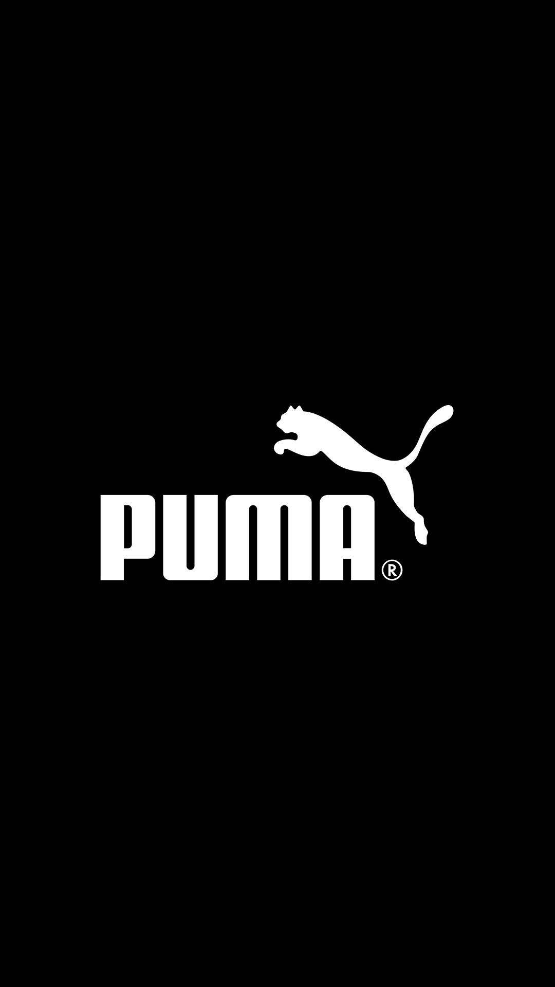 經典Puma品牌標誌 壁紙 — 大膽的白色Puma標誌，中央有跳躍的貓剪影，位於純黑色背景上。