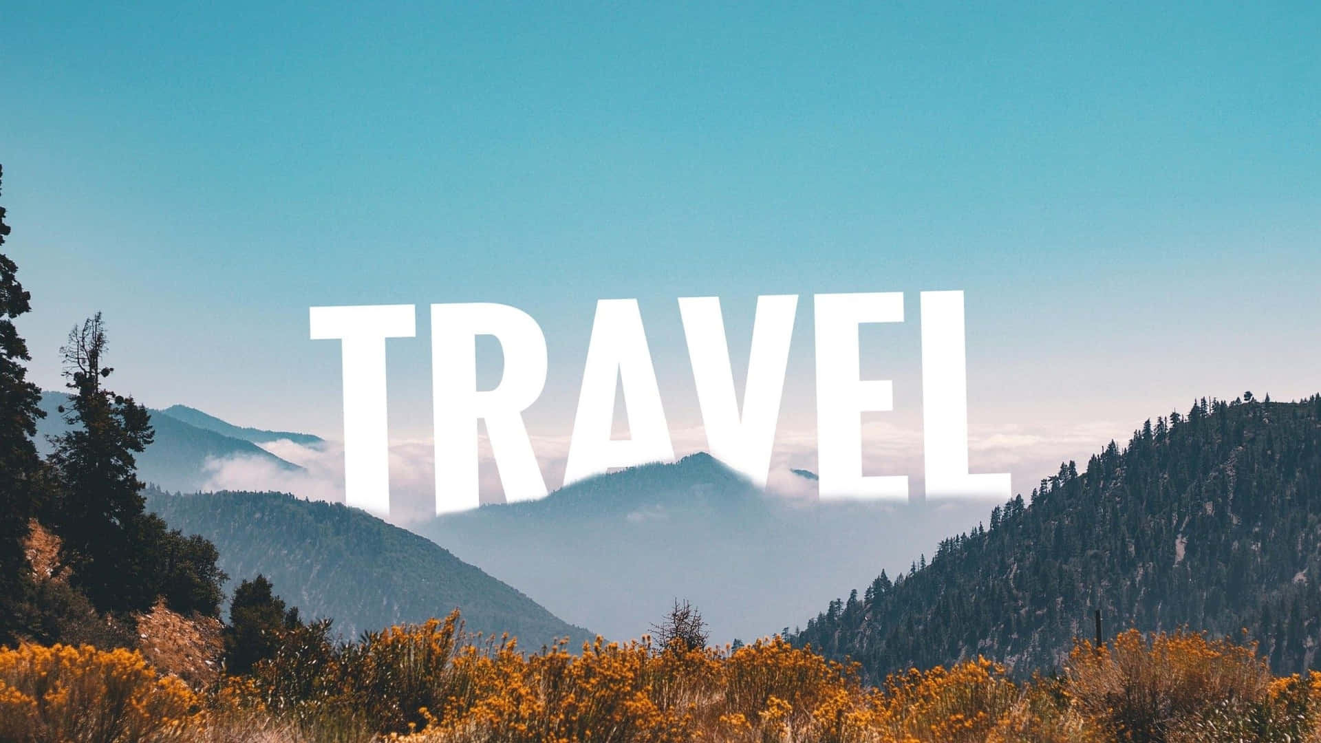  壁紙 — 喺晴朗藍天下，霧氣繚繞嘅山脈同金色灌木之上，粗體白色「TRAVEL」文字。