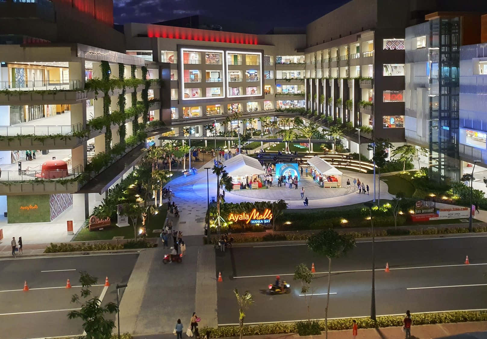 Mall 桌布 壁紙 — Bonifacio Global City 的 Ayala Malls 充滿活力的夜景，閃爍的窗戶和人們享受著燈火通明的戶外廣場。
