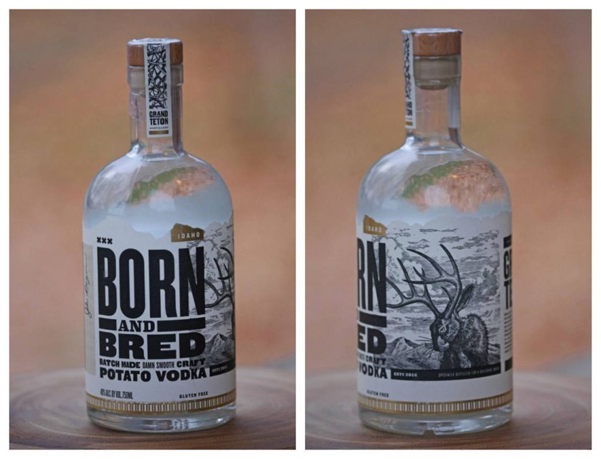 Born And Bred品牌貼紙視覺 壁紙 — 兩瓶 Born and Bred 馬鈴薯伏特加並排展示在木質表面上，背景溫暖模糊。
