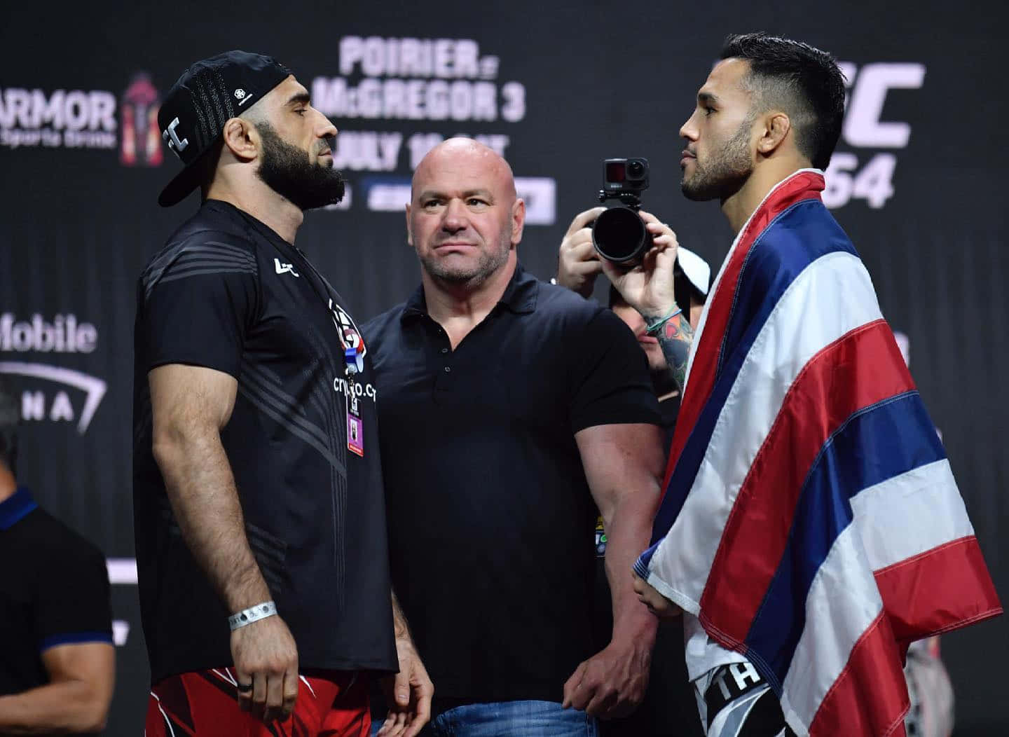 Brad Tavares 準備迎戰 壁紙 — 兩名拳手在UFC過磅中對峙，中間有裁判，相機捕捉緊張時刻。