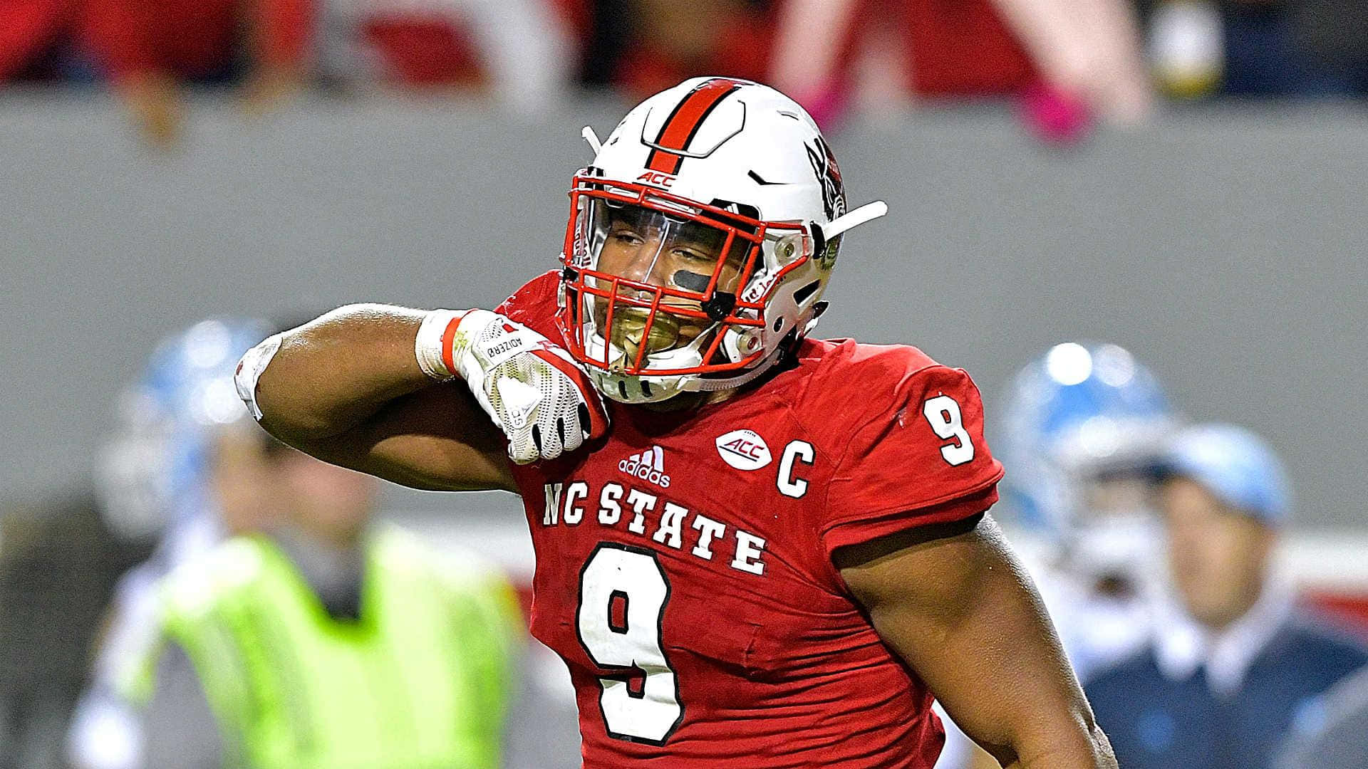 NC State足球員9號在夜間比賽中舉起拳頭慶祝。