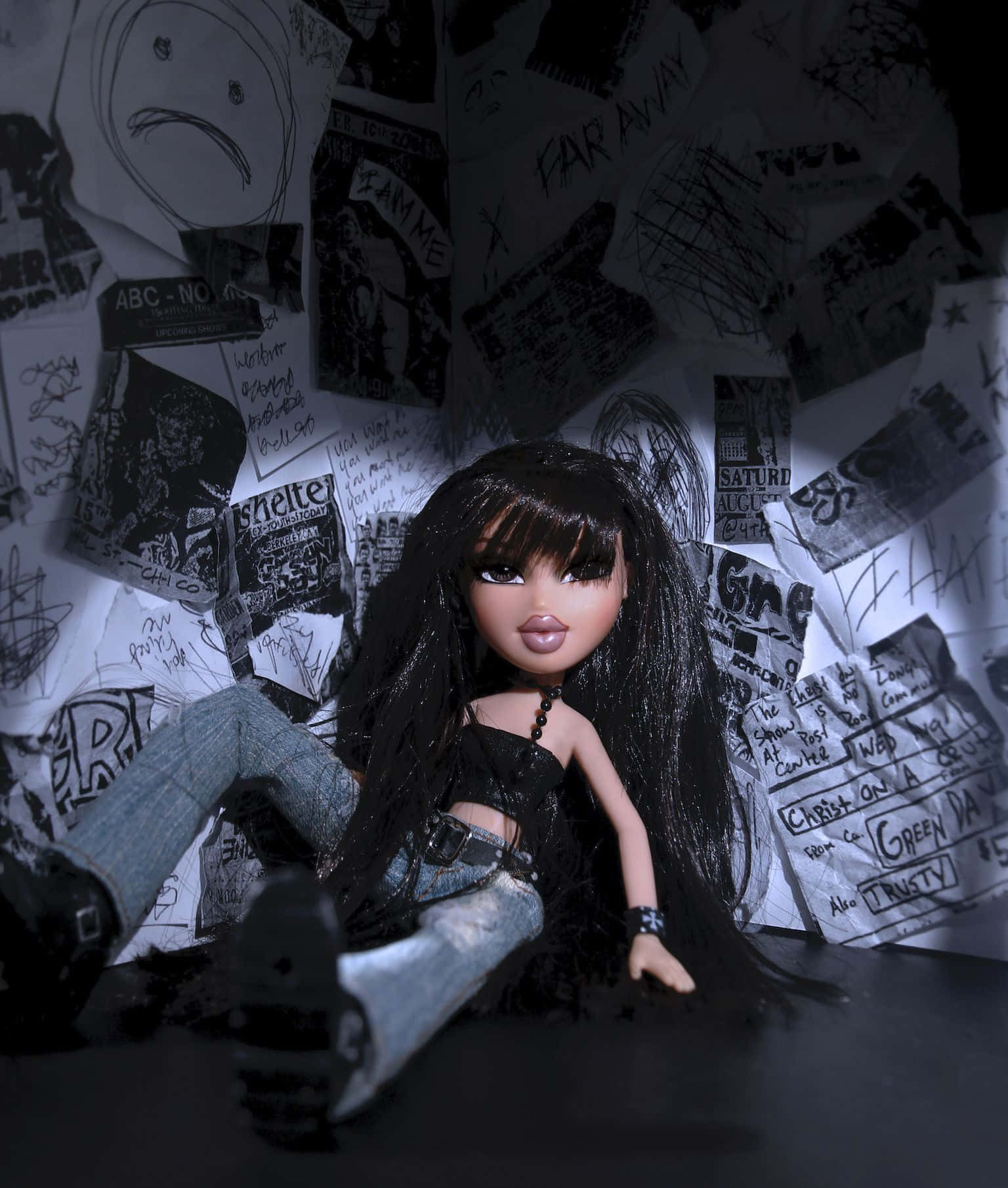 以Bratz美學擁抱個人風格 壁紙 — 一個長黑髮、穿著龐克服飾的洋娃娃坐在昏暗的空間中，周圍環繞著混亂的手寫筆記和圖畫。
