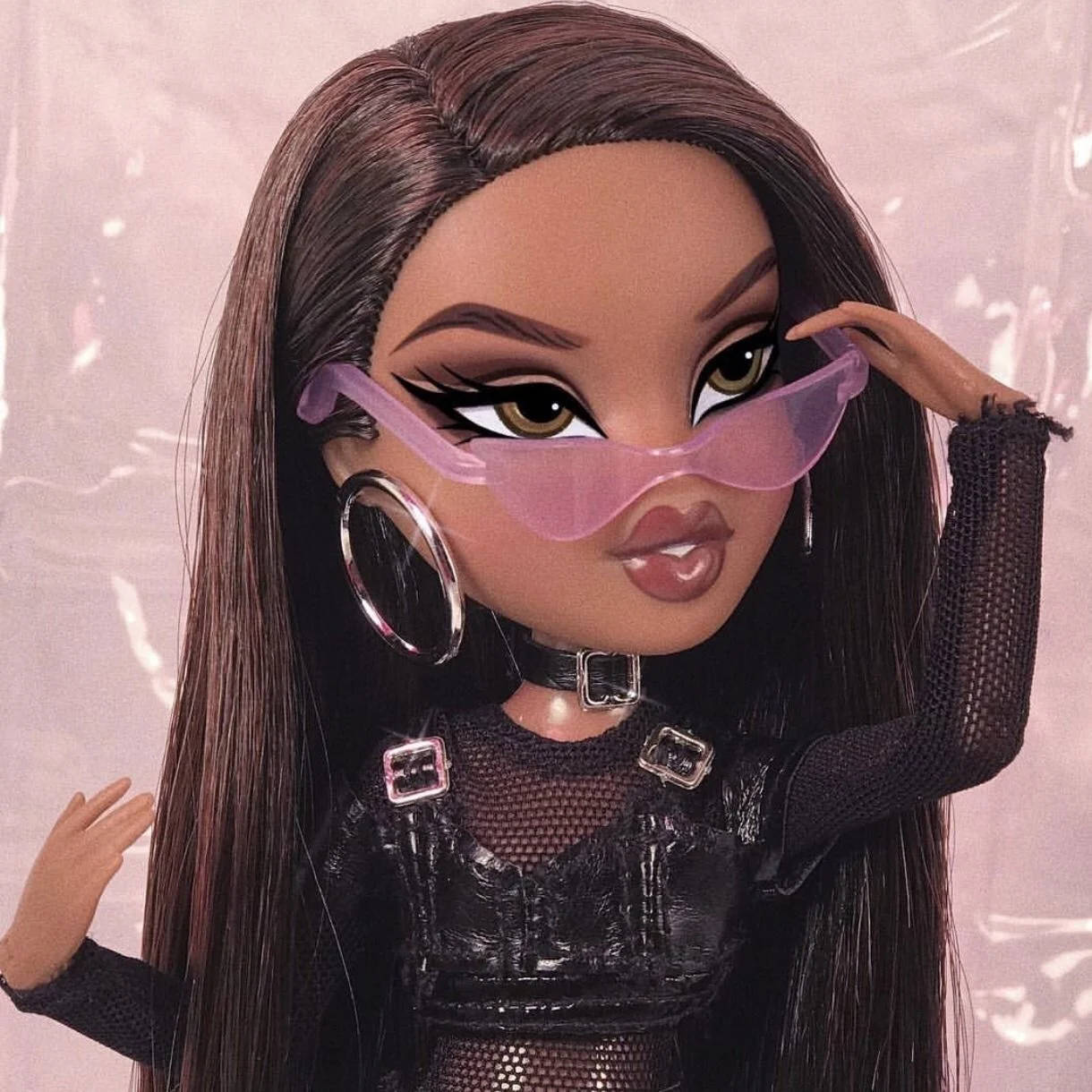 Bratz 公仔戴著粉紅色太陽眼鏡和黑色網狀服裝，配戴耳環。