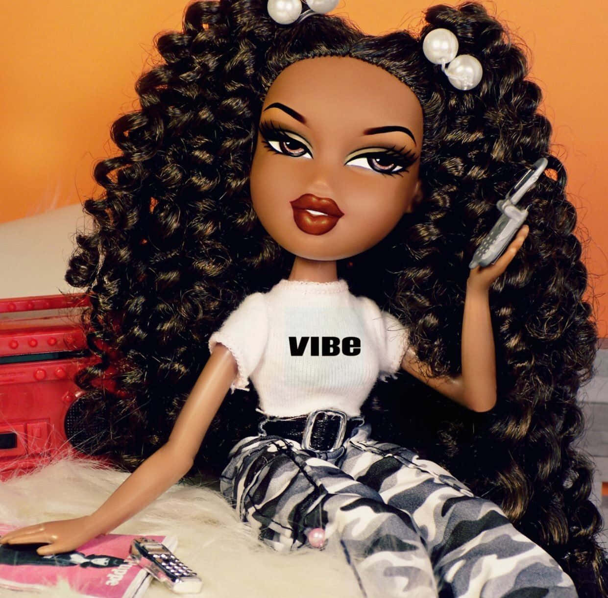 Bratz娃娃氛圍美學 壁紙 — 一個擁有豐盈捲髮和珍珠夾的 Bratz 公仔躺在毛絨地毯上，拿著翻蓋手機。