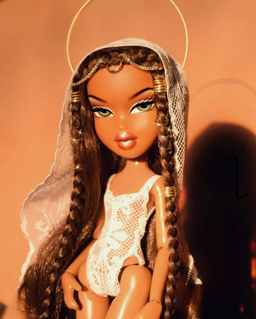 Bratz娃娃經典寫真 壁紙 — 一個辮子頭髮、帶光環的洋娃娃，在溫暖的橙色背景下穿著白色蕾絲連體衣。