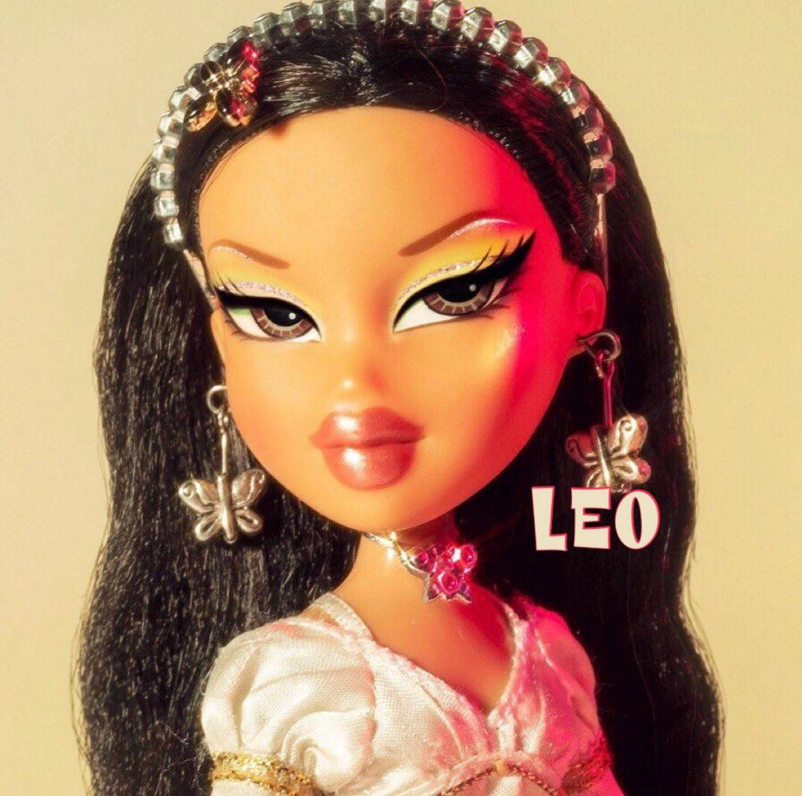 Bratz 公仔戴蝴蝶耳環和珠寶頭帶，穿粉紅色連衣裙。
