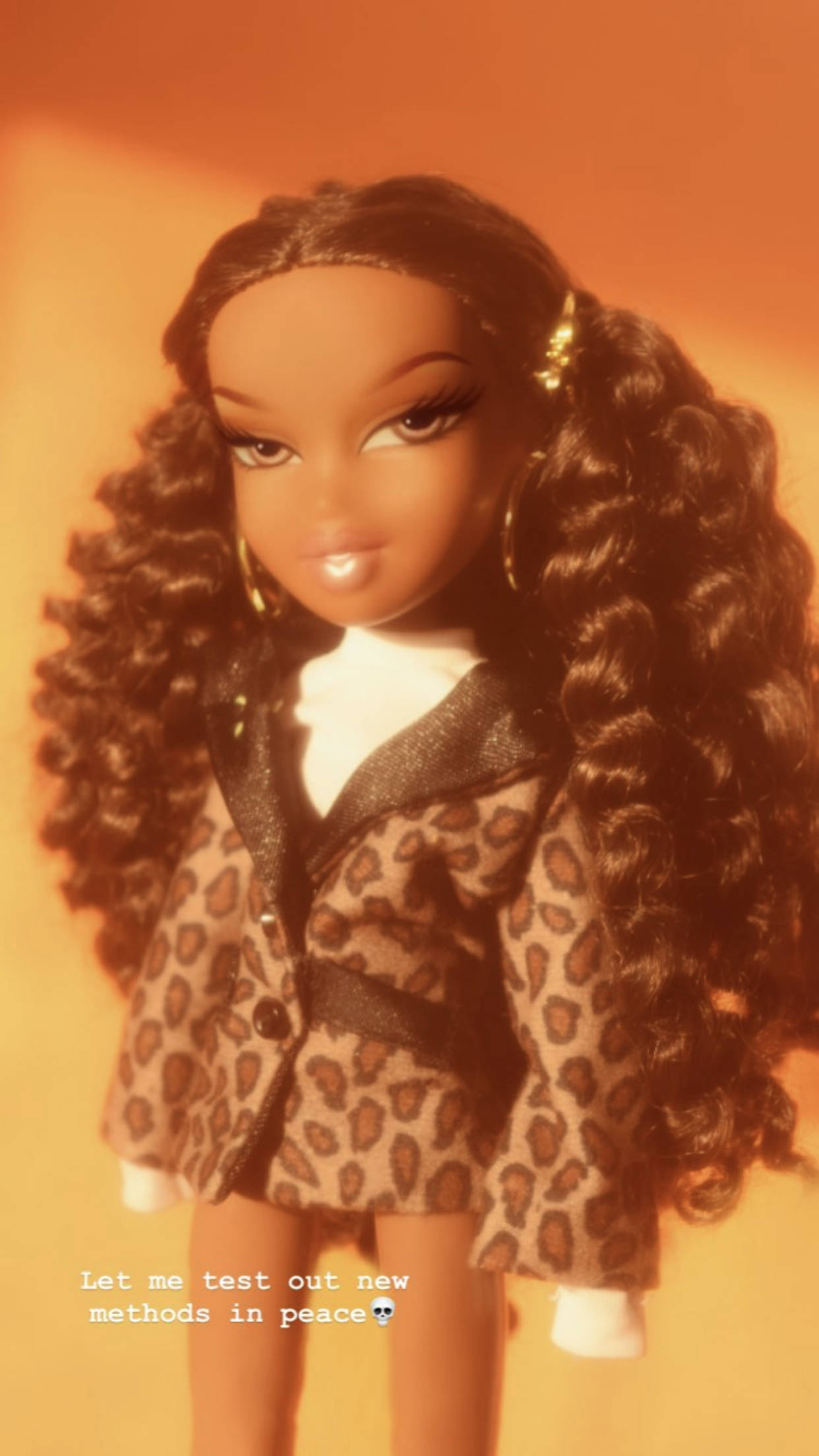 Bratz玩偶捲髮造型 壁紙 — 一個長捲髮、身穿豹紋外套的洋娃娃在溫暖的橙色背景前擺姿勢。