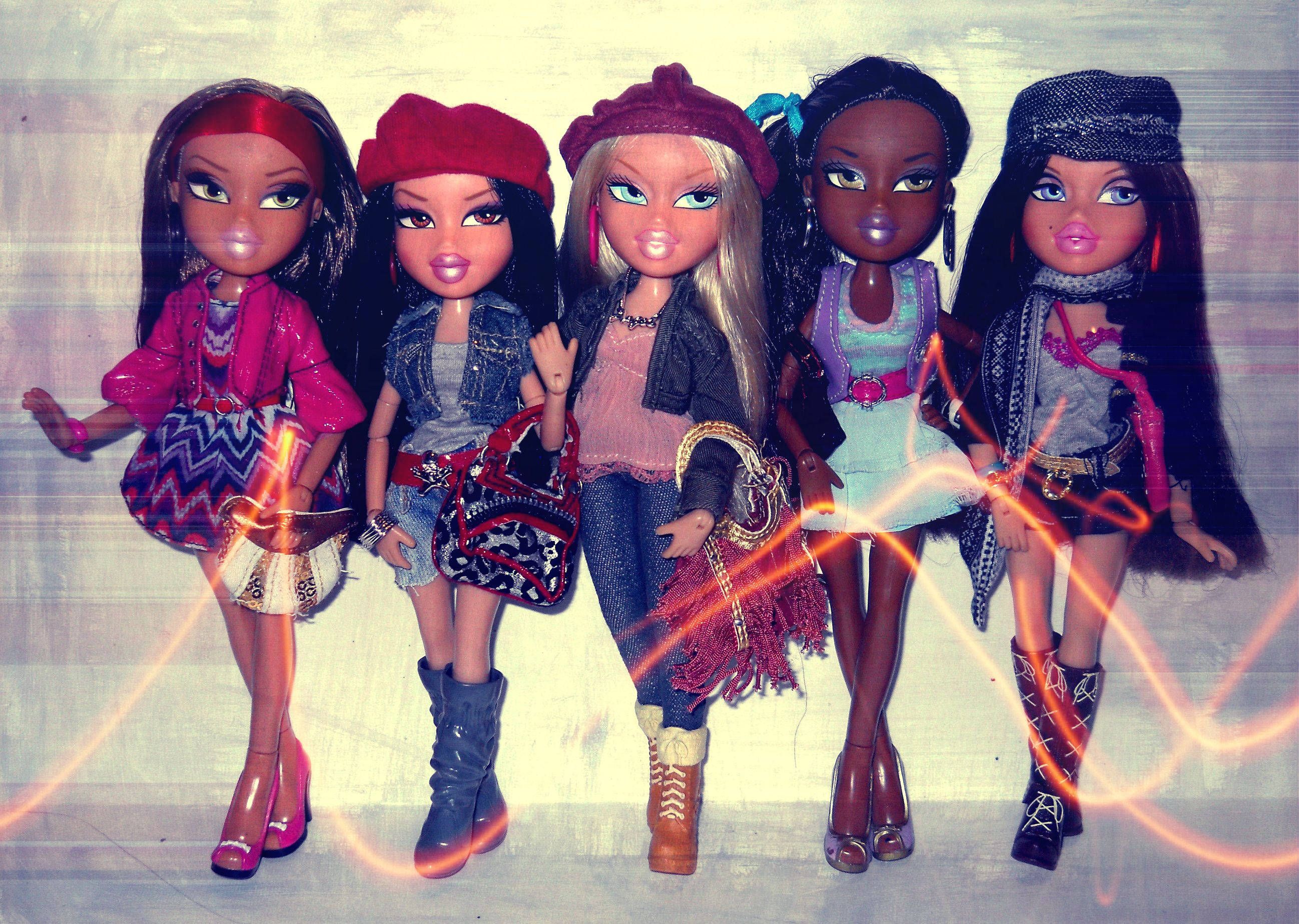 Bratz玩偶群像 壁紙 — 五個穿著時尚服裝的 Bratz 公仔站在有紋理的牆前，牆上有發光的橙色光條。