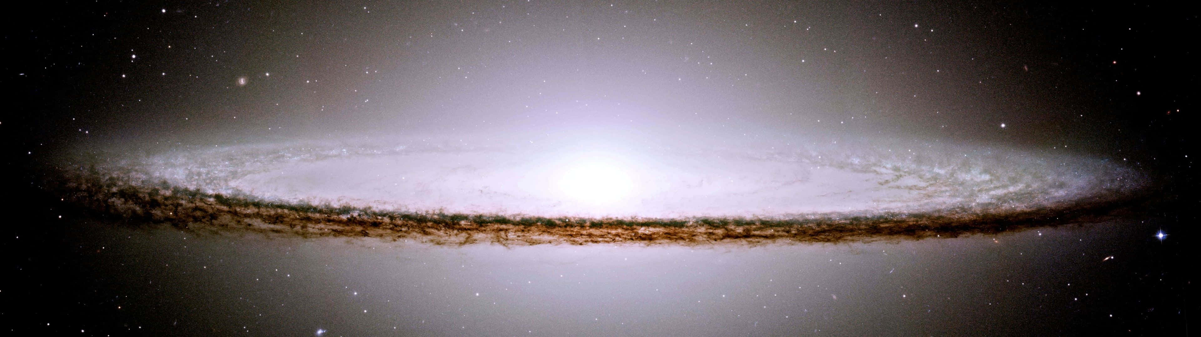  壁紙 — 一個令人嘆為觀止的螺旋星系景象，在繁星點點的宇宙背景下散發出明亮的白色和金色色調。