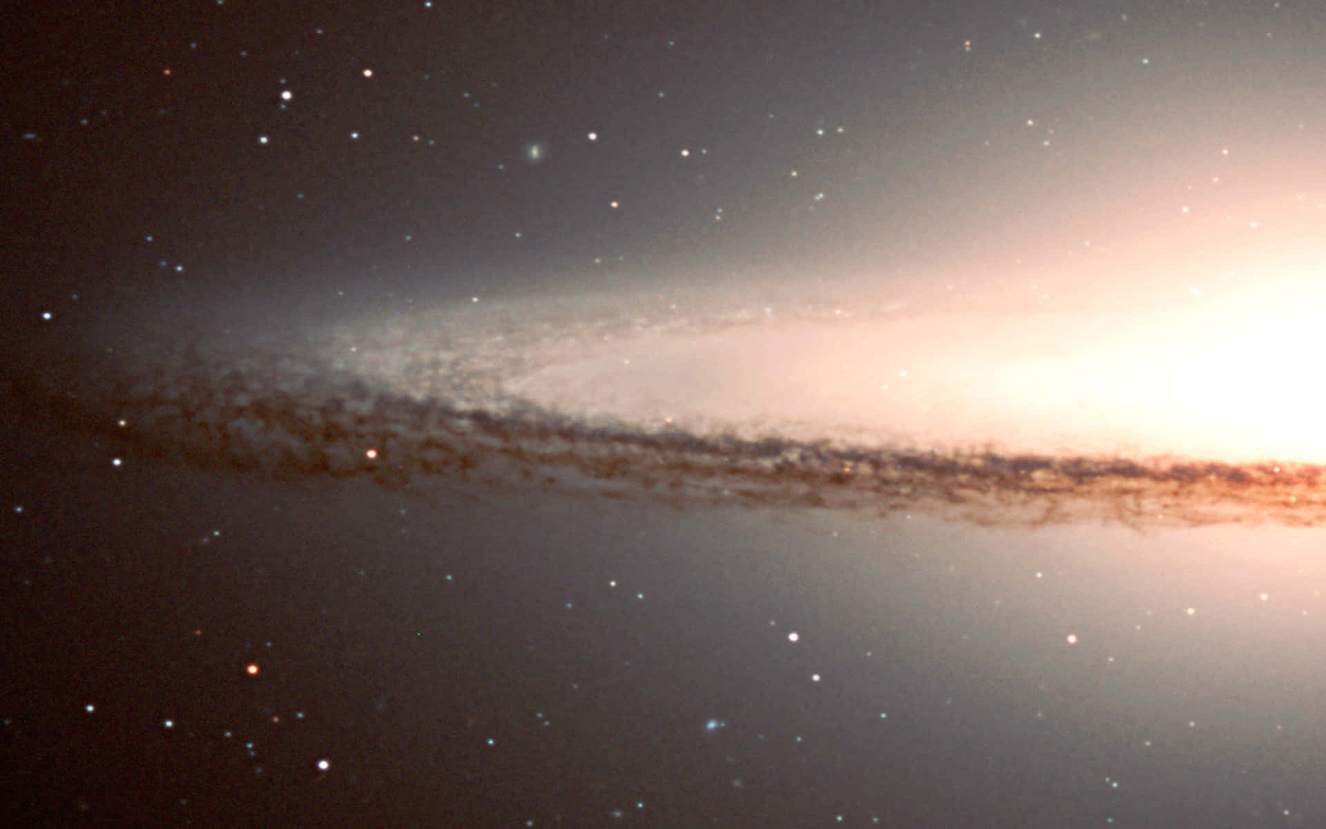  壁紙 — 一個令人嘆為觀止的螺旋星系，在星光燦爛的宇宙背景下散發溫暖光芒。