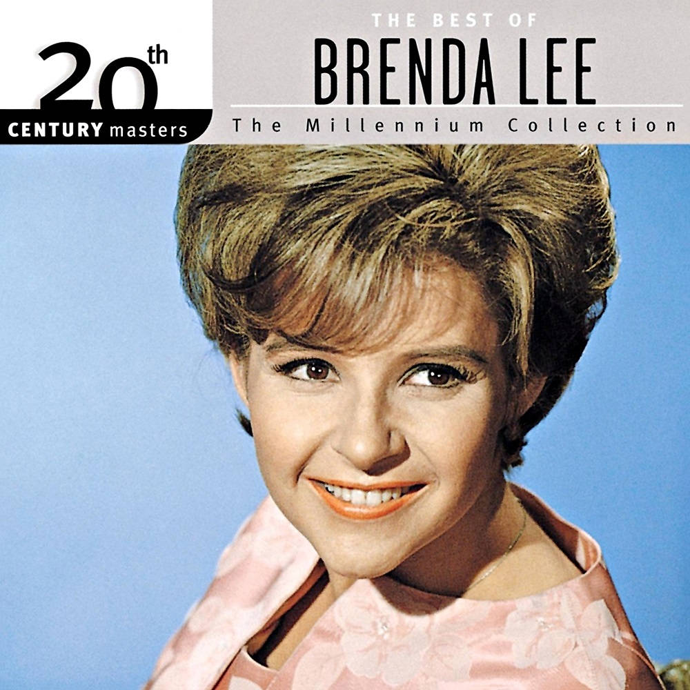 Brenda Lee《The Best Of》音樂專輯封面 壁紙 — Brenda Lee 喺純藍色背景前，穿著粉紅色花卉連衣裙，喺復古專輯封面上燦爛微笑。