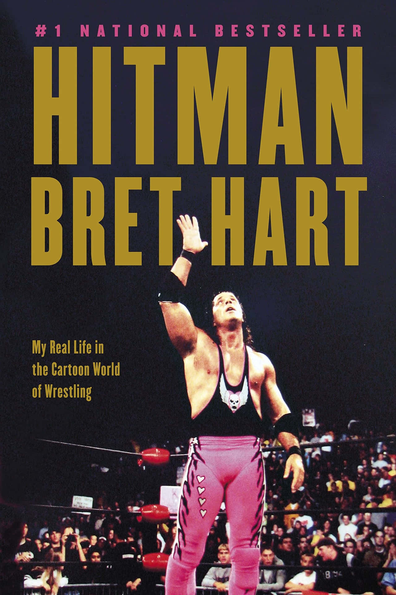 穿著粉紅色緊身褲的摔角手 Bret Hart 在摔角擂台上高舉手，身後是歡呼的人群。