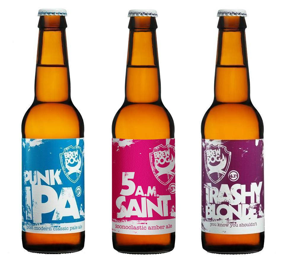BrewDog 三款啤酒：Punk Ipa、5AM Saint 及 Trashy Blonde 壁紙 — 三支琥珀色啤酒瓶，帶有藍色、粉紅色和紫色的醒目塗鴉風格標籤，立在潔白背景上。