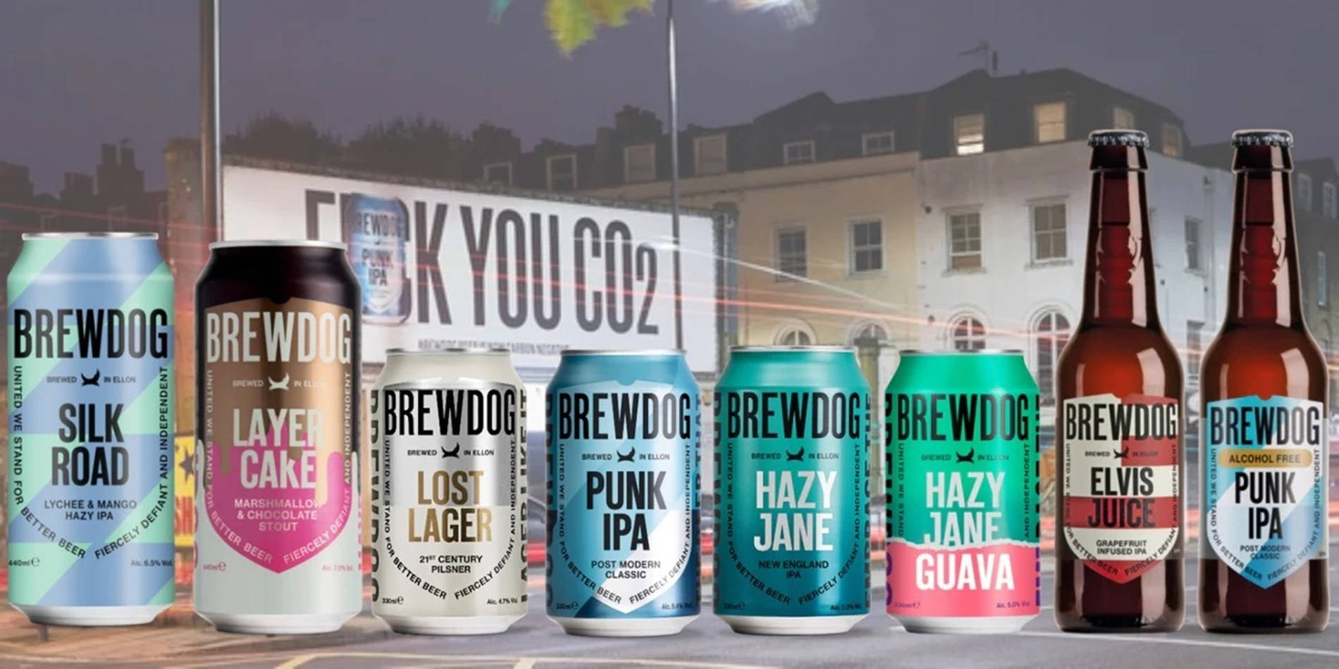 BrewDog 啤酒罐與瓶裝 壁紙 — 一排色彩繽紛的BrewDog啤酒罐和啤酒瓶展示在一棟帶有「F**K YOU CO2」標誌的建築物前。