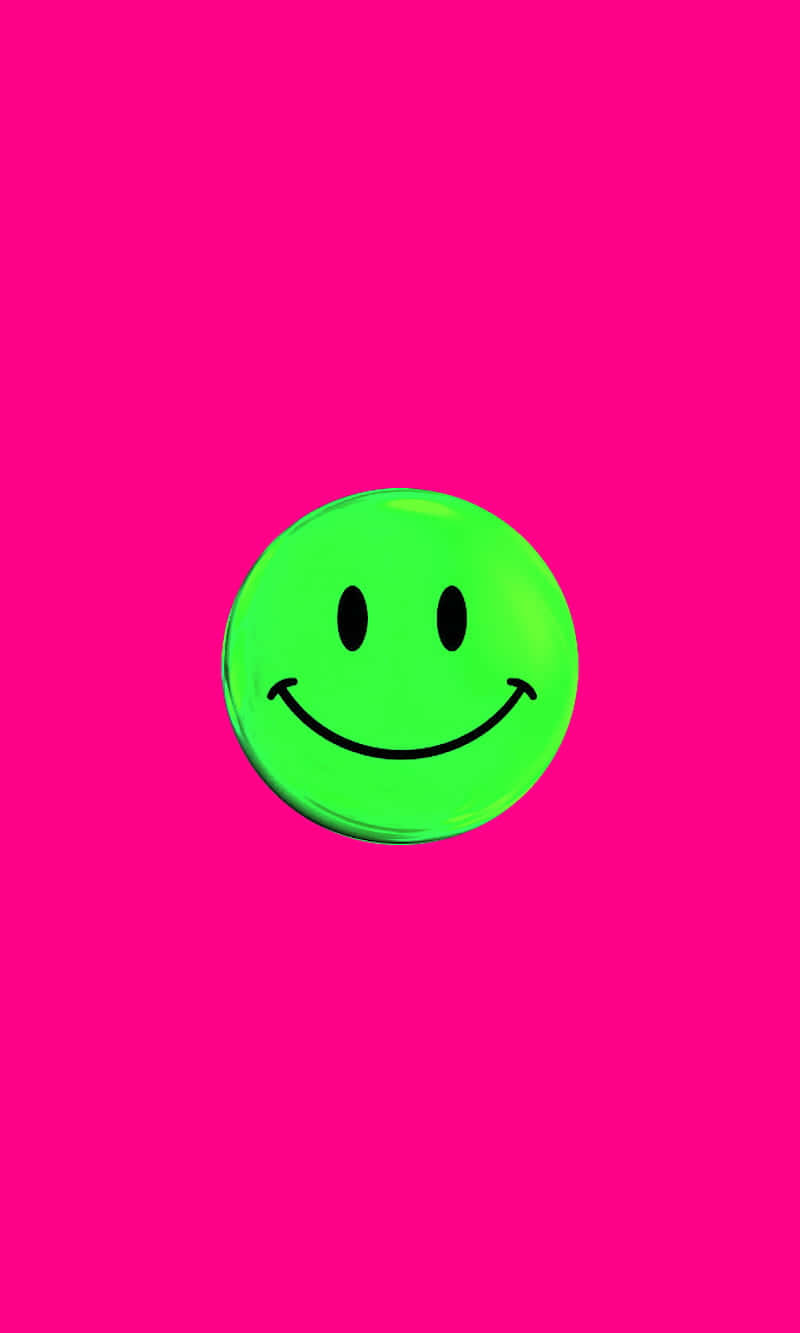 Pink Smiley Face 桌布 壁紙 — 一個明亮的綠色笑臉圖標，居中在鮮豔的粉紅色背景上，帶有柔和的光線。
