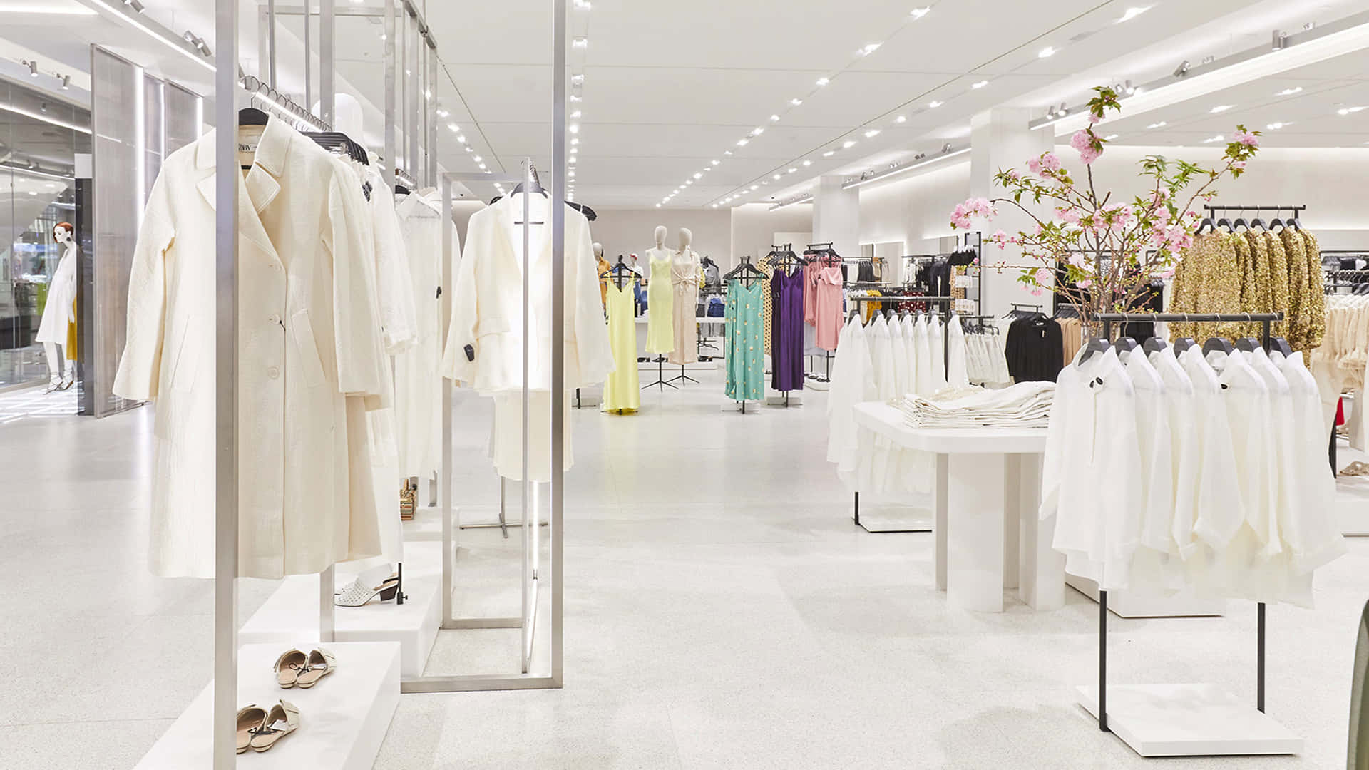 極簡主義服裝店，白色貨架和人體模型展示優雅的服裝。