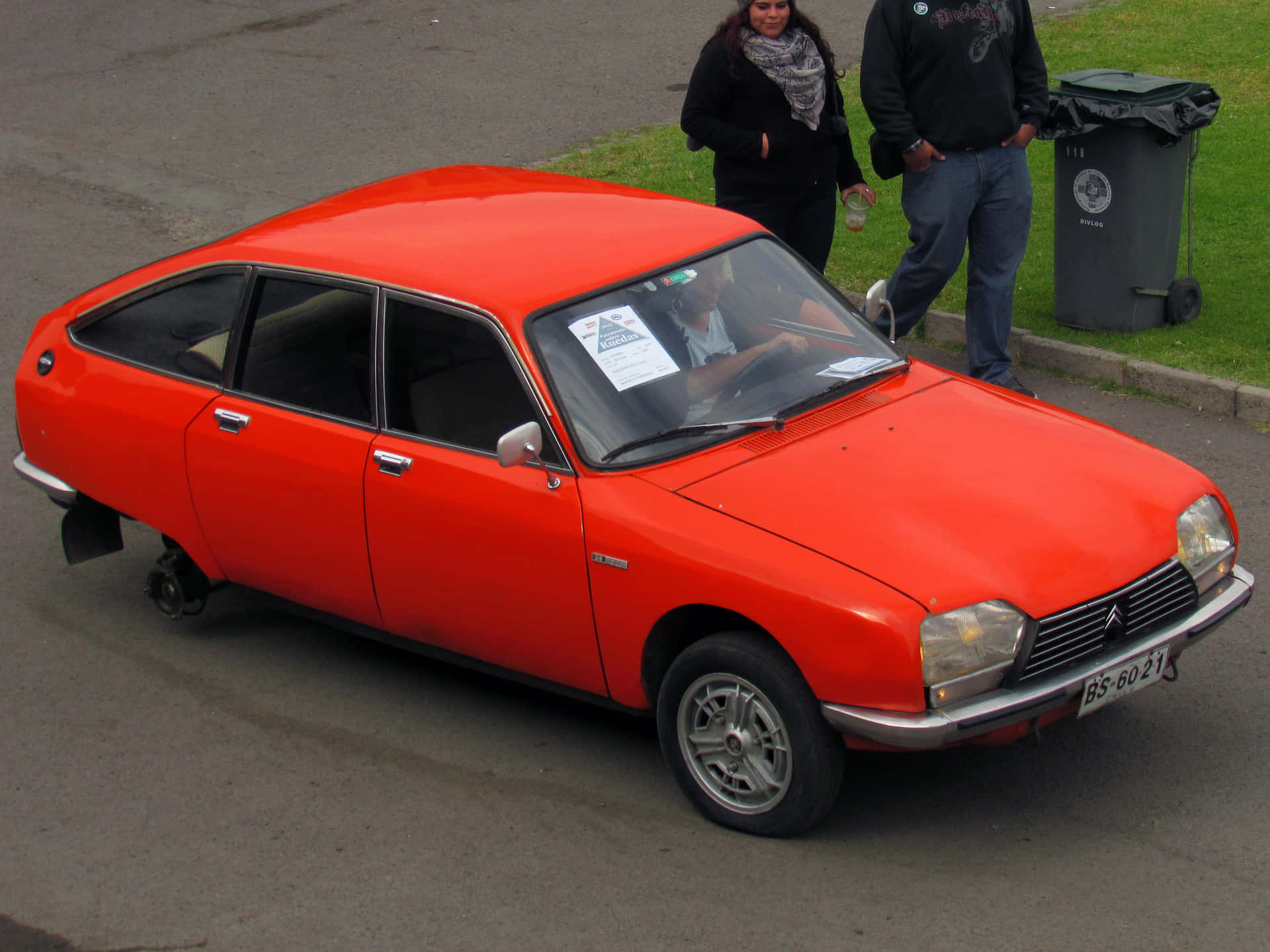  壁紙 — 一輛鮮紅色嘅 vintage Citroën DS 車泊喺街度，附近有兩個人企喺度。