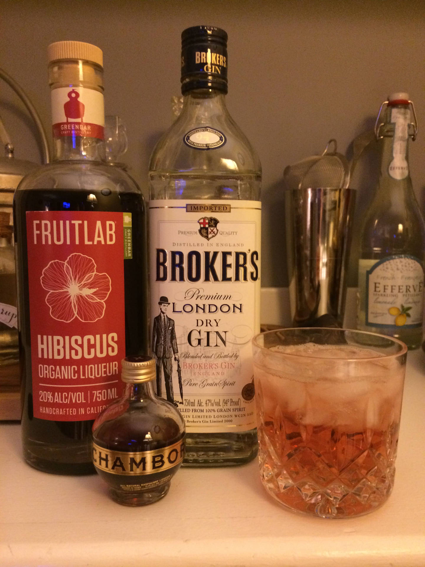 酒吧枱上放有氈酒瓶和一個裝滿冰塊和琥珀色液體的雞尾酒杯。