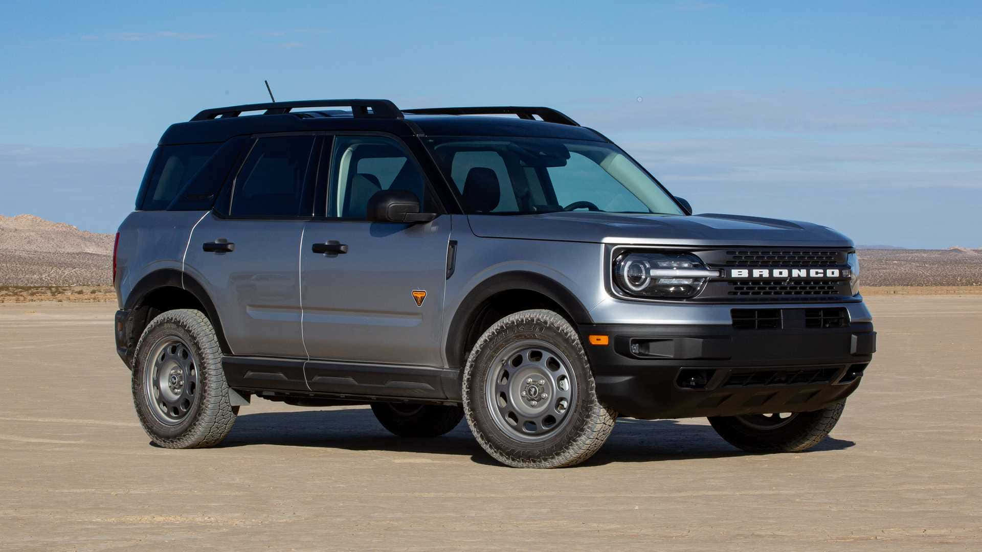 時尚且堅固——福特Bronco 壁紙 — 一架時尚的銀色福特Bronco SUV在晴朗藍天下，立於廣闊沙漠平原，遠方有岩石丘陵。