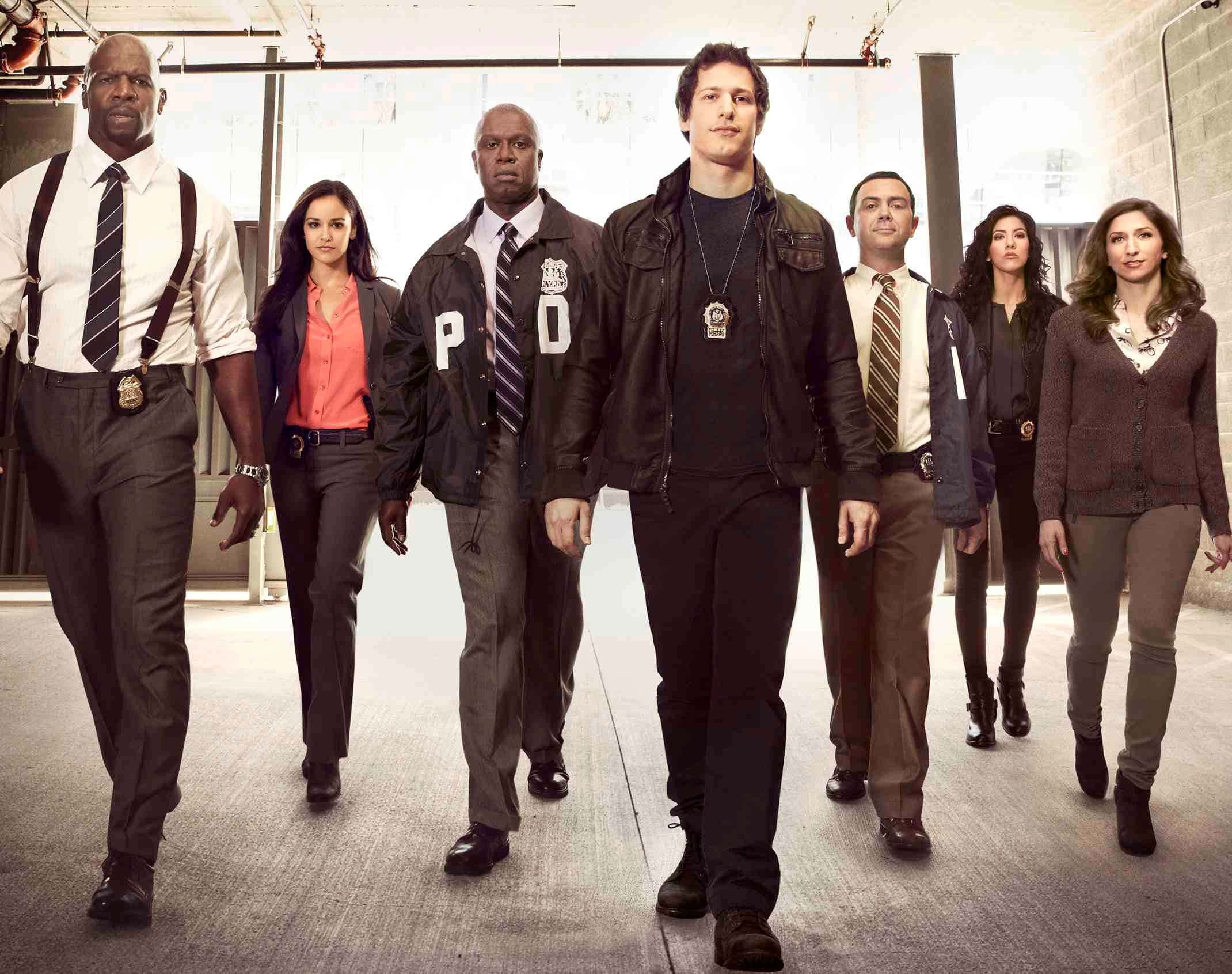 《Brooklyn Nine-Nine》全體演員風采盡顯 壁紙 — 七名身穿制服和休閒服裝的警察自信地走在帶有工業照明的混凝土走廊上。