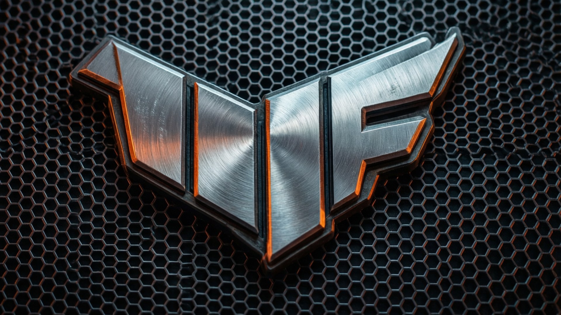 Brushed Metal TUF Logo 壁紙 — 一個拉絲金屬 'VF' 標誌，帶有發光的橙色邊緣，放置在深色六角形網格格柵上。