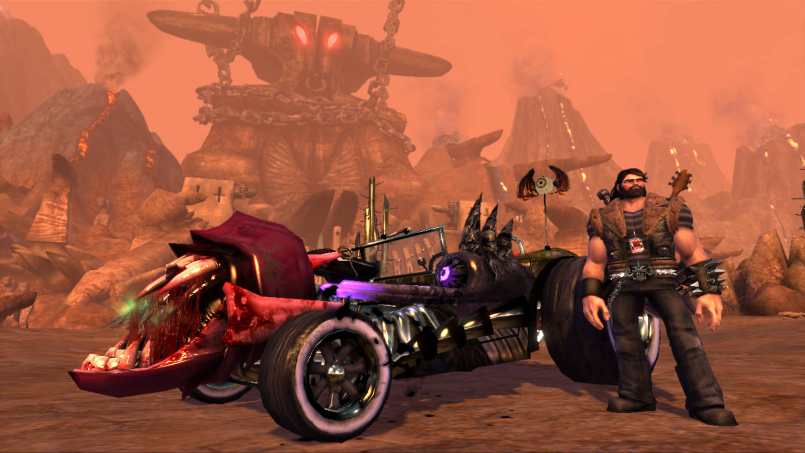 Brutal Legend 艾迪與戰車 壁紙 — 一個肌肉發達的電單車手站在一輛長滿牙齒的怪獸電單車旁邊，背景是熾熱的沙漠荒地，一個巨大的機械廢墟發出紅光。