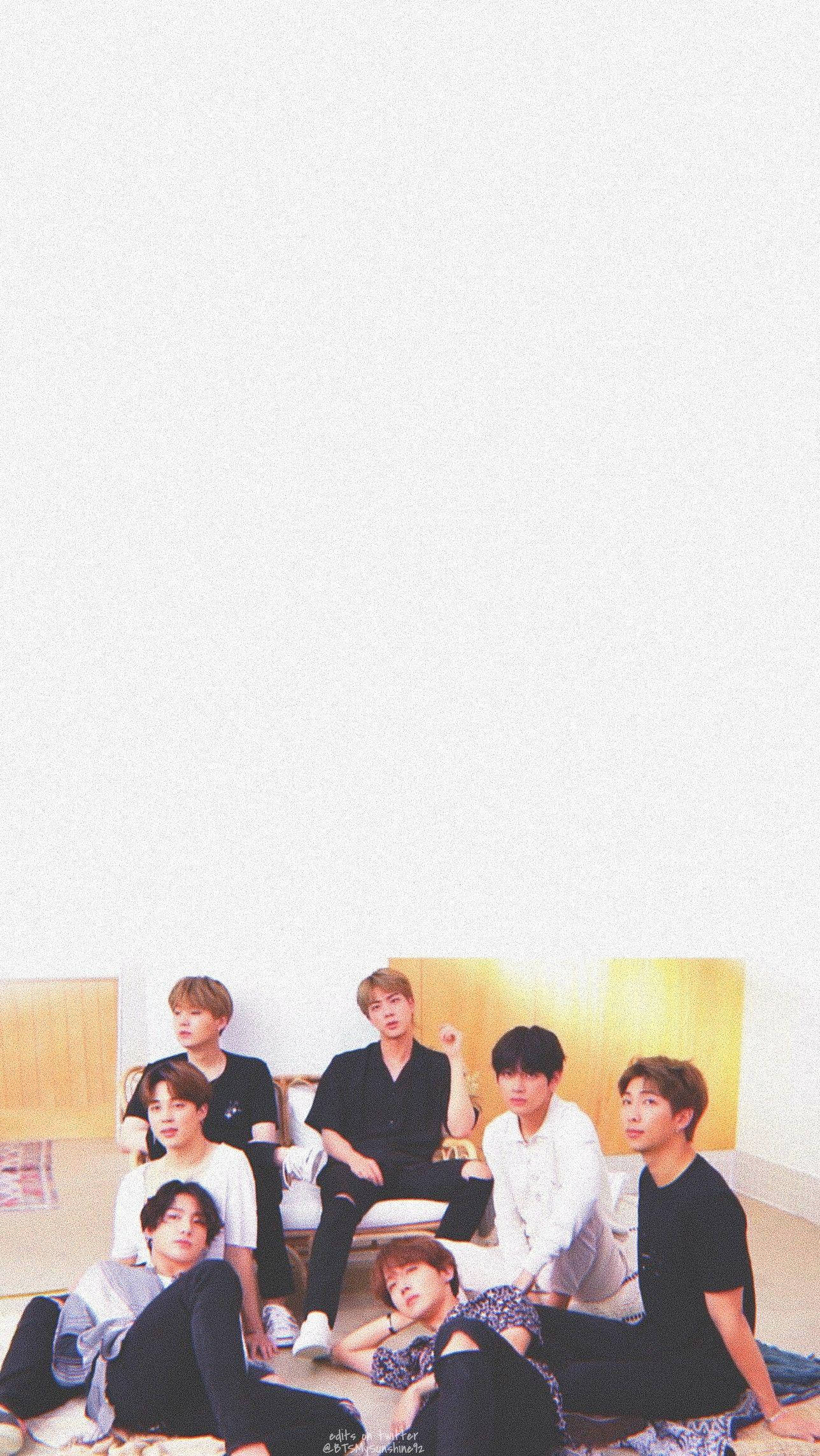 BTS 2020 放鬆照 壁紙 — 七位年輕男士身穿休閒服裝，在舖有木地板的白色牆壁前，放鬆地坐在地上擺姿勢。