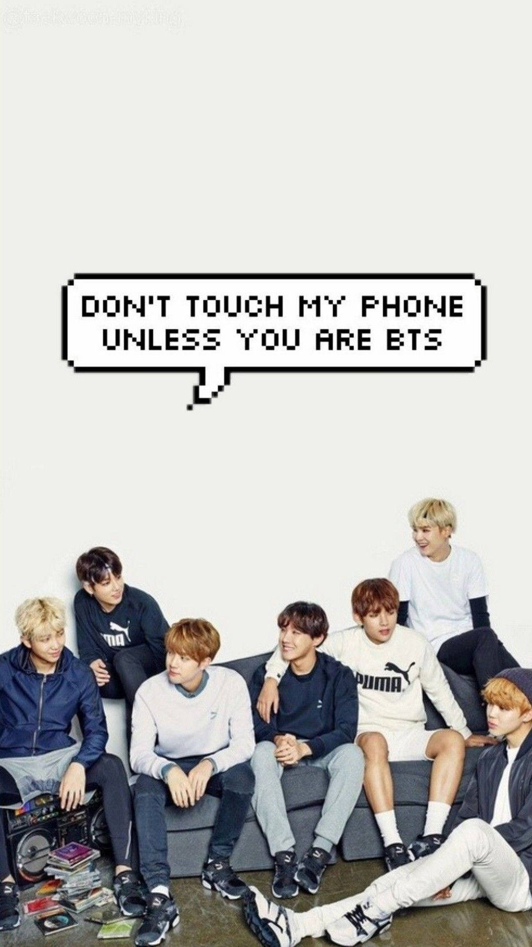 七個年輕男子坐在沙發上，旁邊有一個像素對話框，上面寫著 don't touch my phone unless you are bts。