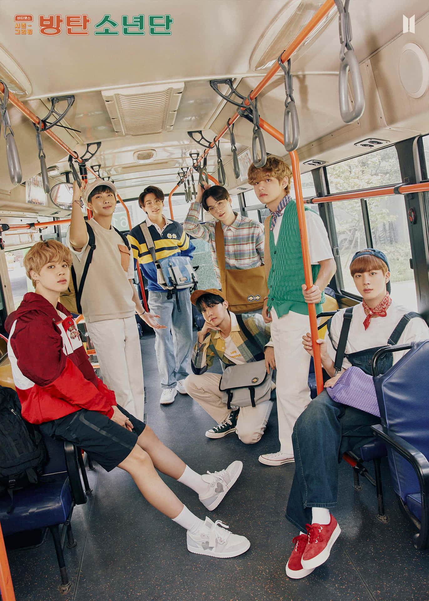 BTS 2021 季節問候照片 壁紙 — 七位身穿色彩繽紛休閒裝的年輕男子在陽光普照的公共巴士內充滿活力地擺姿勢，巴士有橙色扶手和藍色座椅。