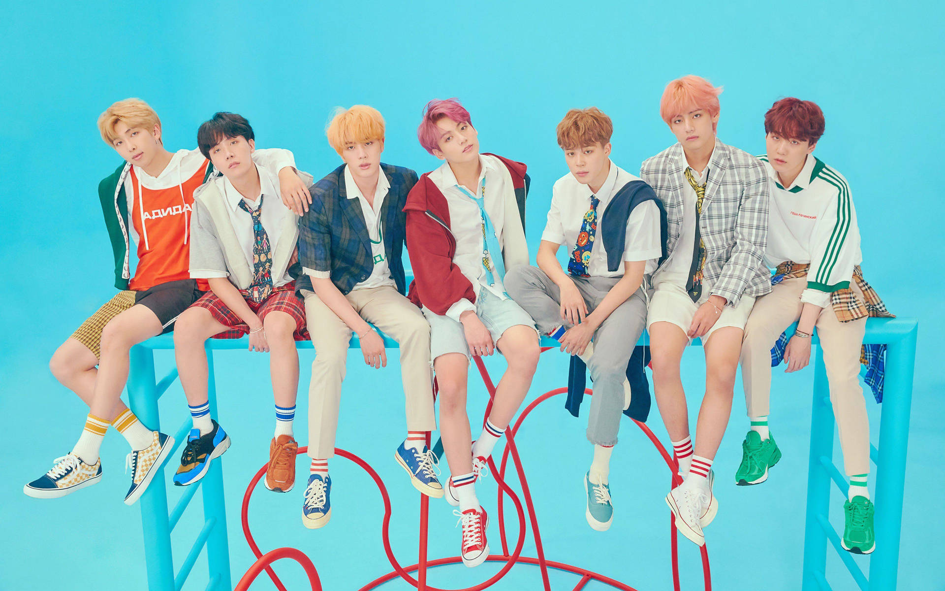 BTS《Answer》概念預告靈感筆電佈置 壁紙 — 七位時尚的年輕男子，頭髮色彩繽紛，隨意地坐在亮藍色的長椅上，背景是純青色。