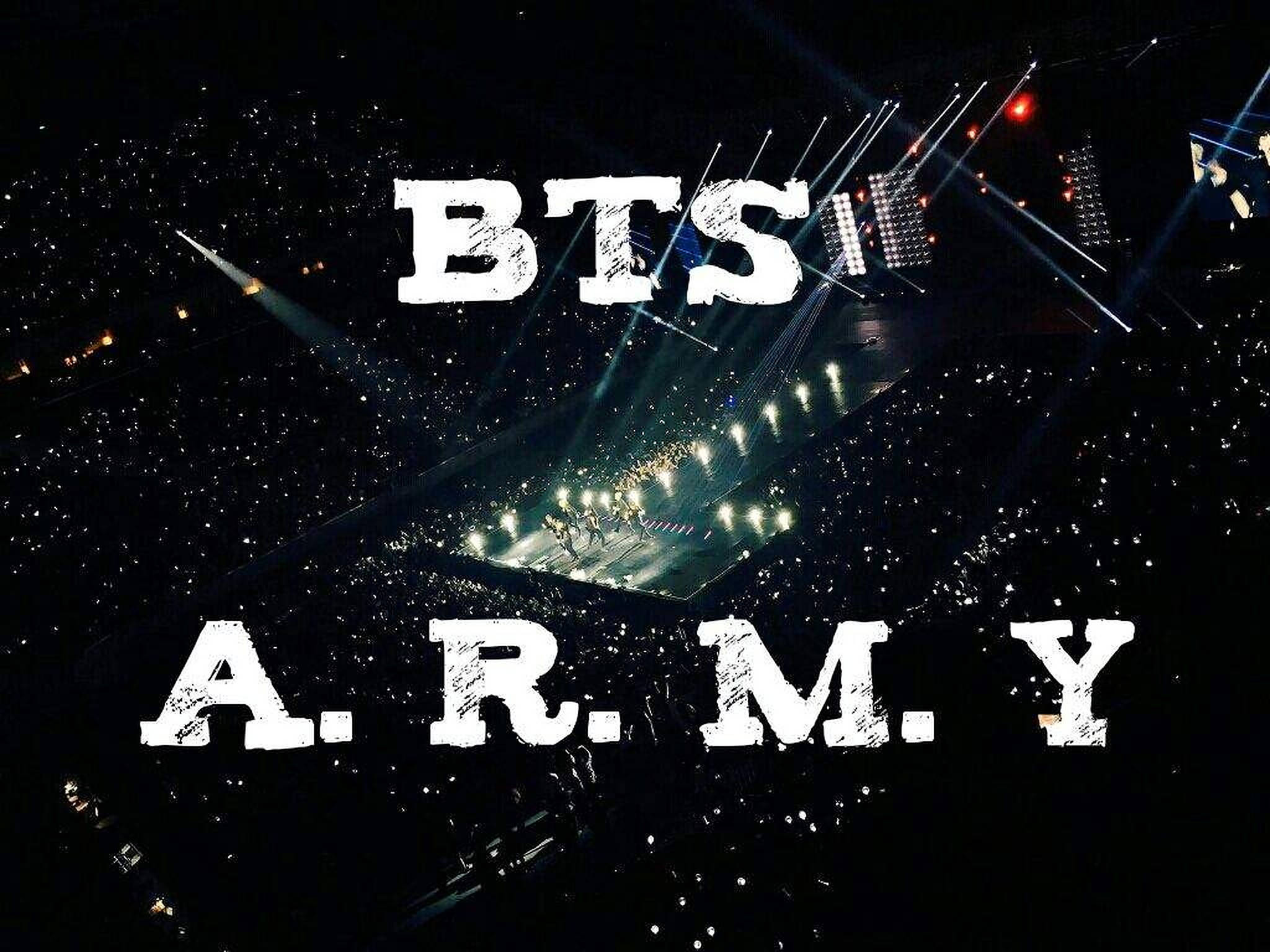 BTS粉絲於體育場 壁紙 — BTS 在夜晚明亮舞台上演出的鳥瞰圖，下方人群中的手機燈光如海洋般閃爍。