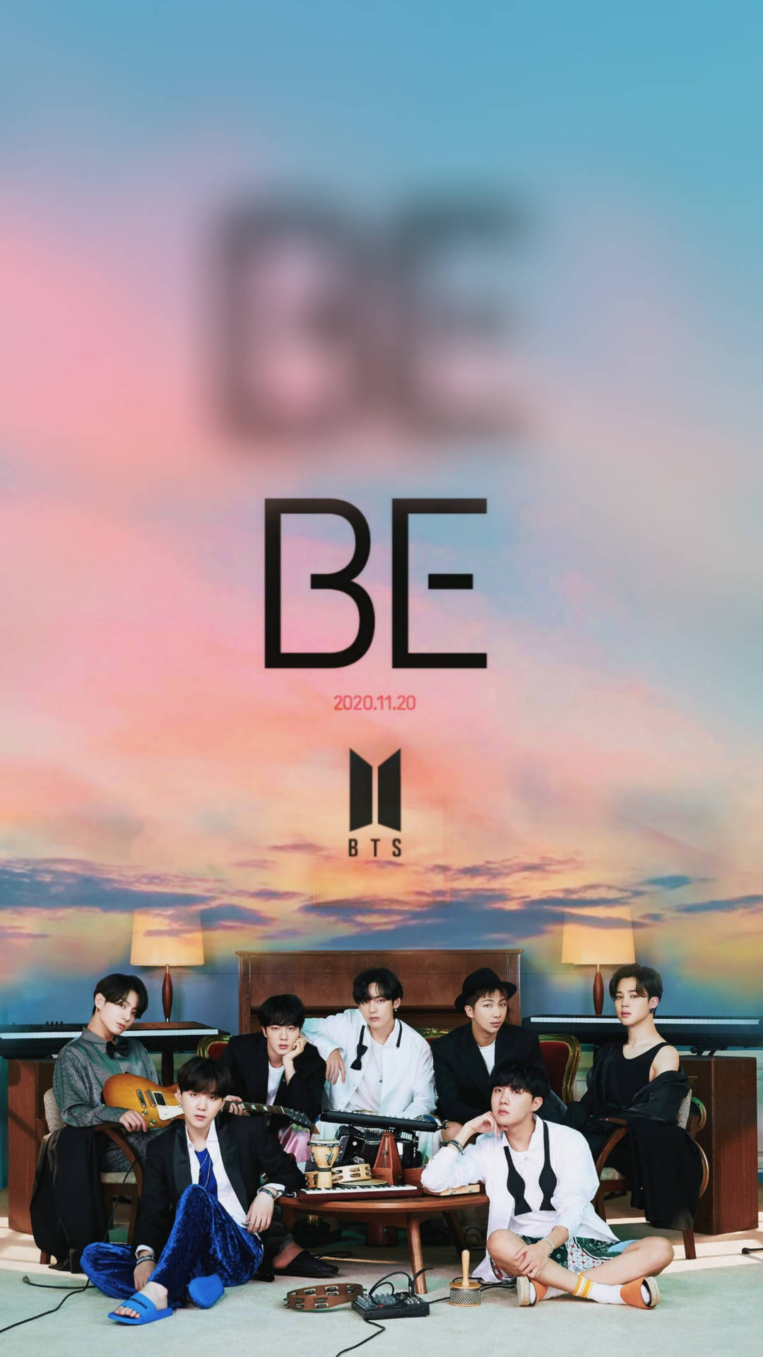 BTS《BE》專輯海報鎖屏 壁紙 — 七位穿著時尚的年輕男子在溫暖照明的房間內休閒地坐著，背景是充滿活力的日落天空和巨大的「BE」文字。