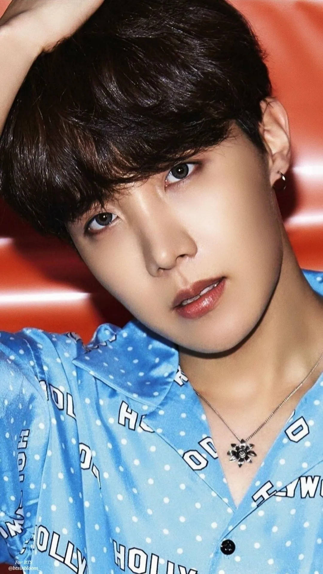 BTS J-hope Lights 壁紙 — 一位黑髮、雙目有神的年輕男子，在鮮紅色背景前擺姿勢，身穿藍色圓點襯衫。