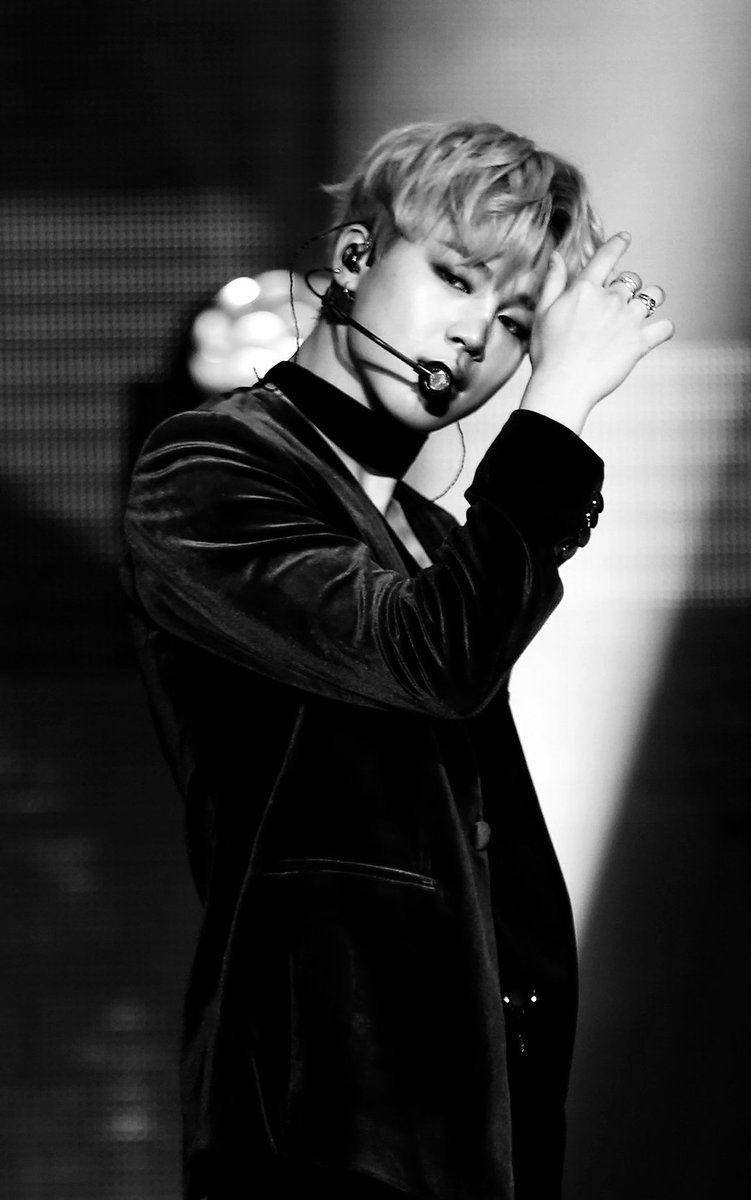 BTS 黑色 Jimin 壁紙 — 一位男表演者在舞台上單手整理頭髮，戴著麥克風耳機的黑白肖像。