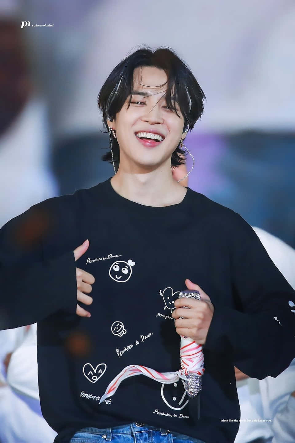 K-pop 表演者在舞台上手持麥克風，露出燦爛的笑容。 — Jimin GIF 壁紙