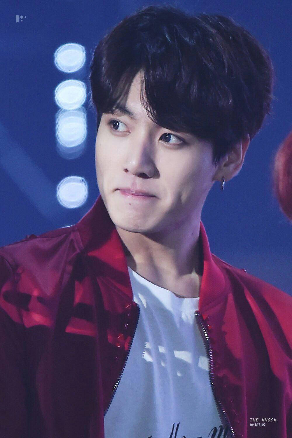 BTS JK 2018金唱片大獎 壁紙 — 一位黑髮年輕男子在舞台燈光下穿著紅色外套，表情嚴肅。