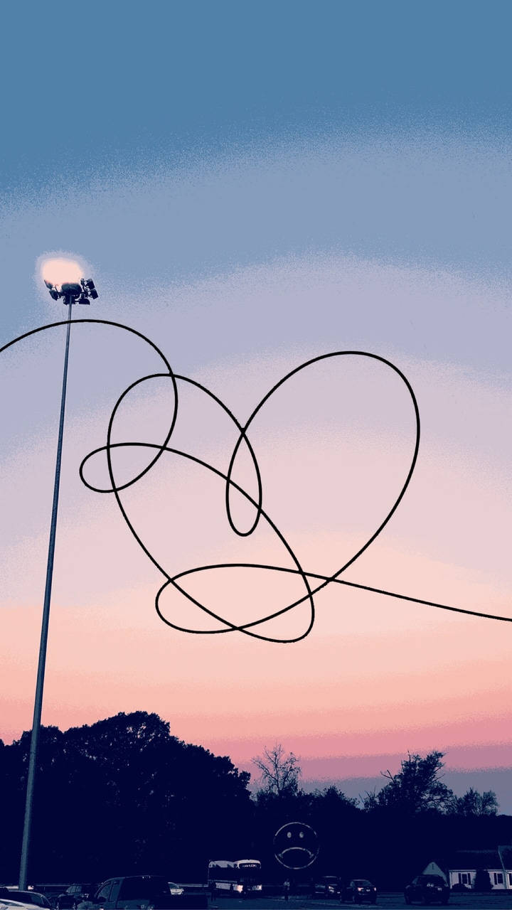 BTS《Love Yourself》標誌美學壁紙 壁紙 — 一條纏繞的黑色電線在暮色天空下形成心形，上方有體育場燈光閃耀。