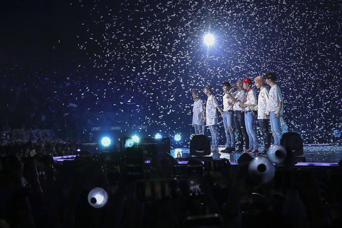 BTS《Love Yourself》演唱會結尾 壁紙 — 七位表演者站在燈光明亮的舞台上，五彩紙屑如雨般灑落在黑暗的音樂會人群上。