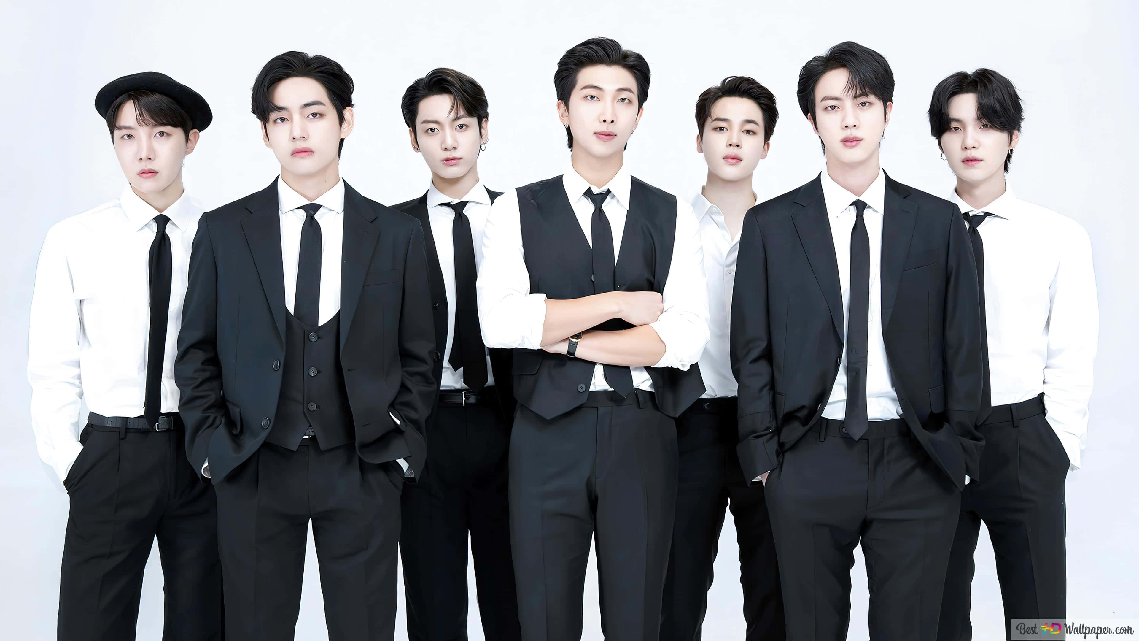 BTS黑白正裝拍攝 壁紙 — 七位穿著黑色西裝和白色襯衫的時尚男士在純白色背景前自信地擺姿勢。