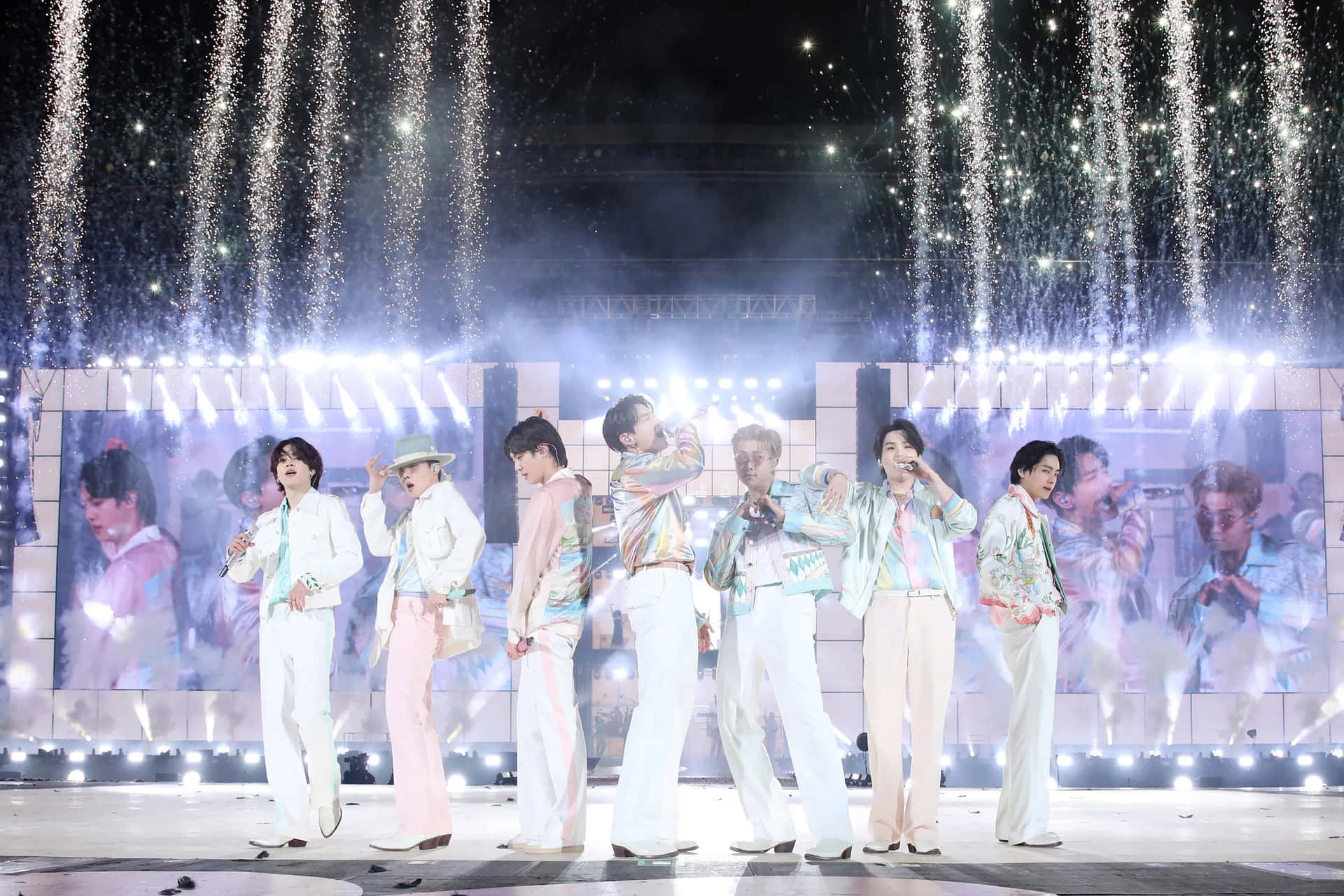 K-pop 組合在閃爍燈光的璀璨舞台上表演。