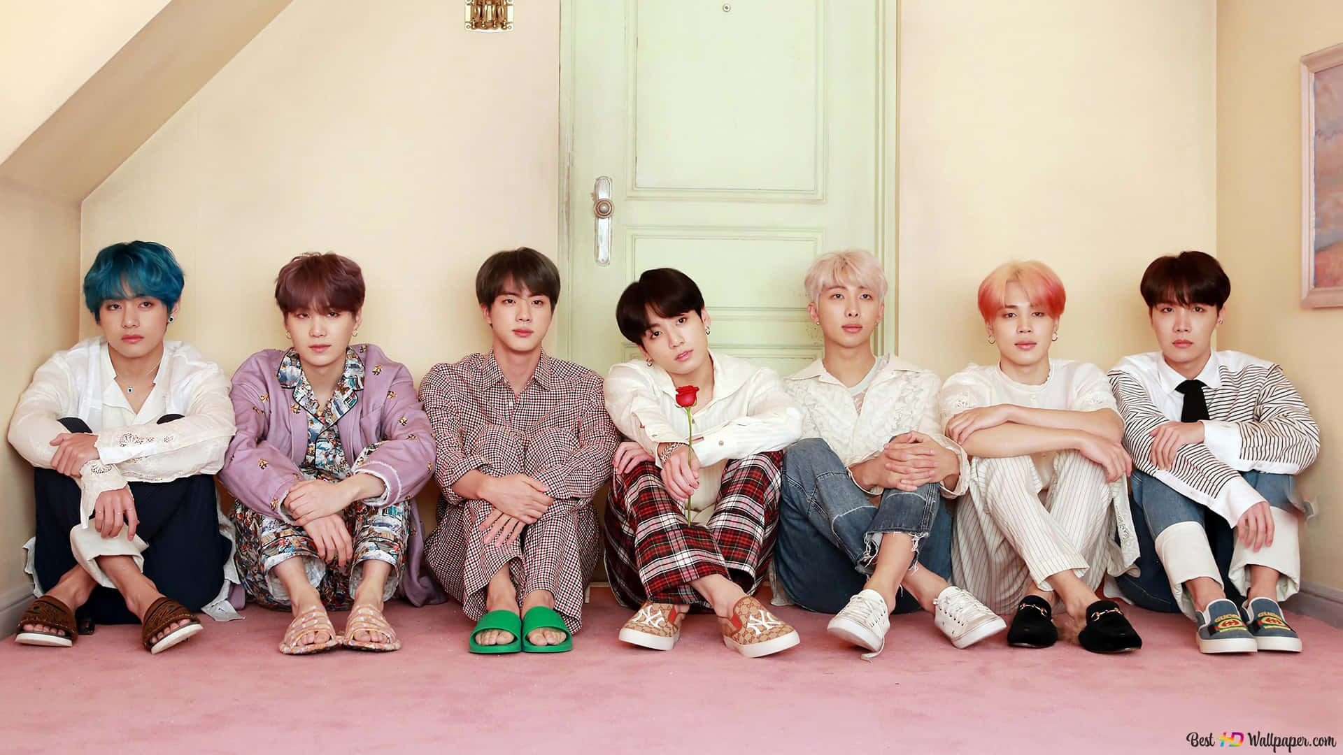 BTS Persona概念拍攝 壁紙 — 七個年輕男子有色彩繽紛的頭髮，隨意地坐在粉紅色地板上，背景是淺綠色門，在舒適的閣樓房間裡。