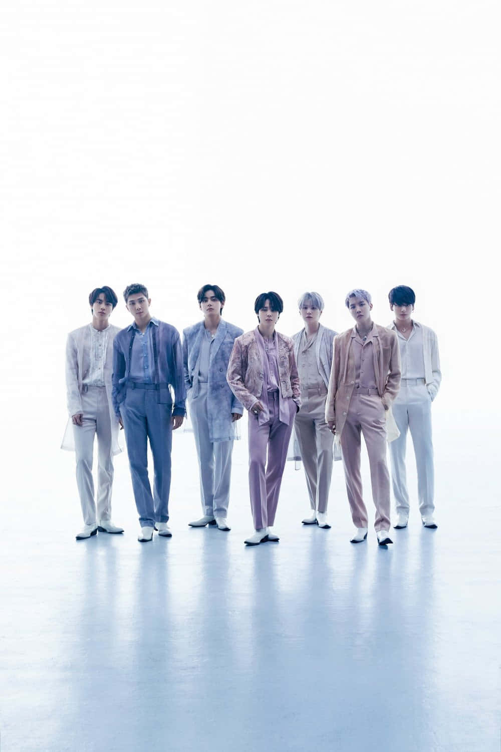 BTS Proof專輯概念拍攝 壁紙 — 七位穿著粉彩色西裝的時尚男士自信地站在明亮的白色攝影棚背景前，地板具有反射效果。
