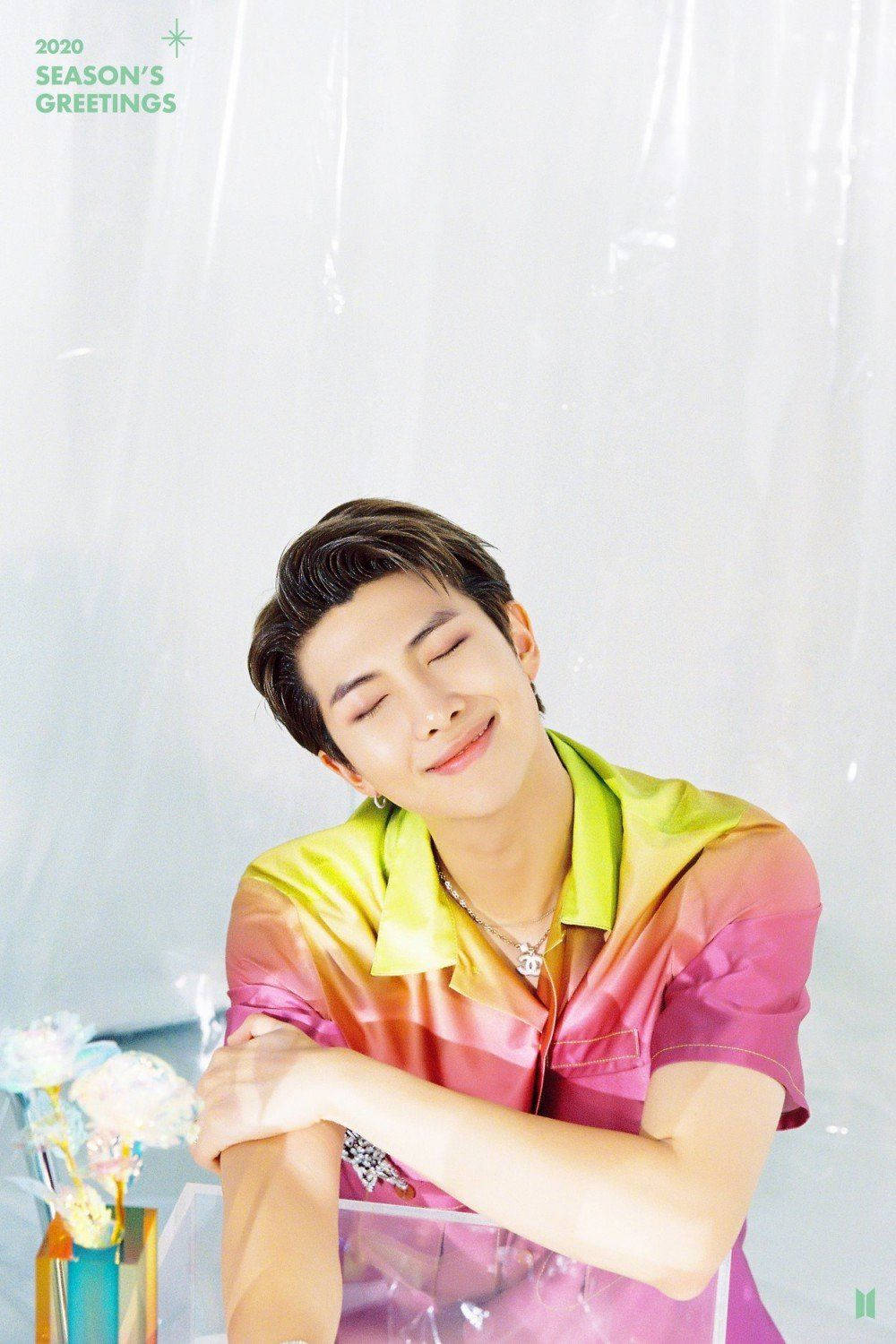 BTS RM 2020 壁紙 — 一位身穿鮮豔漸變襯衫的年輕男子，在柔和的白色背景前閉上眼睛，平靜地微笑。