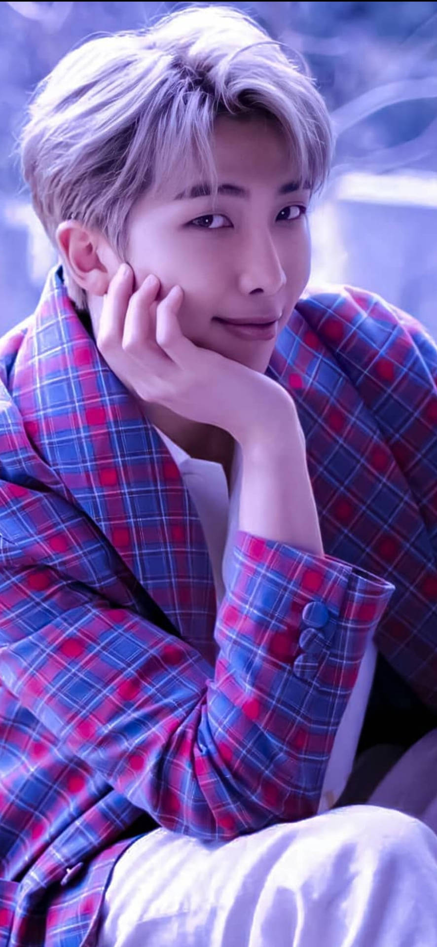 BTS RM 紫色美學 壁紙 — 一位銀髮年輕男子在冷紫色燈光下，身穿紅藍格紋外套，手托下巴。