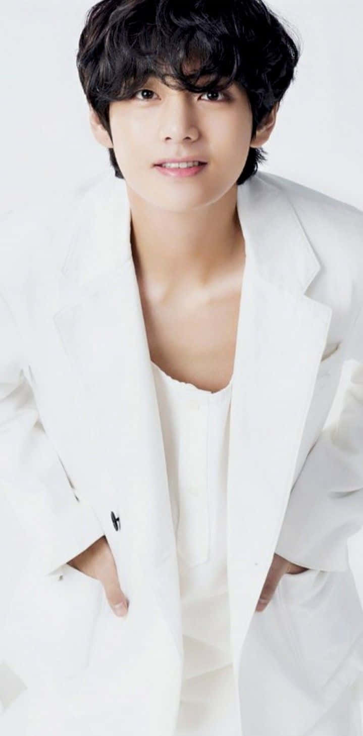 BTS V 以時尚造型展現自信 壁紙 — 一位深色頭髮的年輕男士穿著一件 oversized 白色西裝外套，內搭白色上衣，背景為純白色。