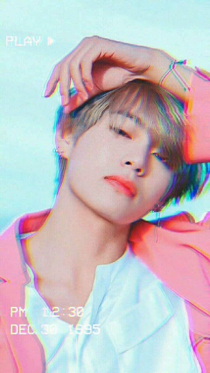 BTS V 以迷人魅力征服人心 壁紙 — 一位短髮年輕人將手放在頭上，背景為帶有故障效果的粉彩背景，並覆蓋 'PLAY' 和日期文字。