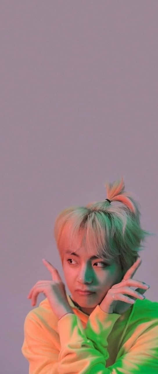 BTS V 為BTS增添力量與溫暖 壁紙 — 一位擁有彩色頭髮和鮮豔連帽衫的年輕男子，在柔和的紫色背景和霓虹燈光下擺姿勢。